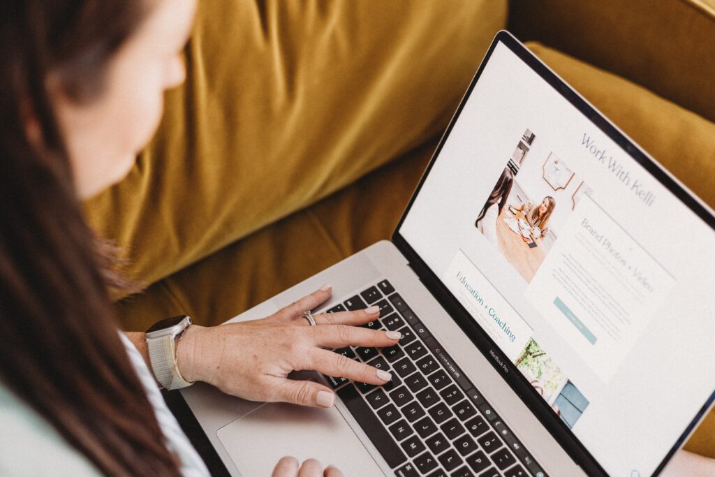 Creative business owner working in a cozy workspace with notebooks, a laptop, and a brand strategy layout – preparing your business for a break